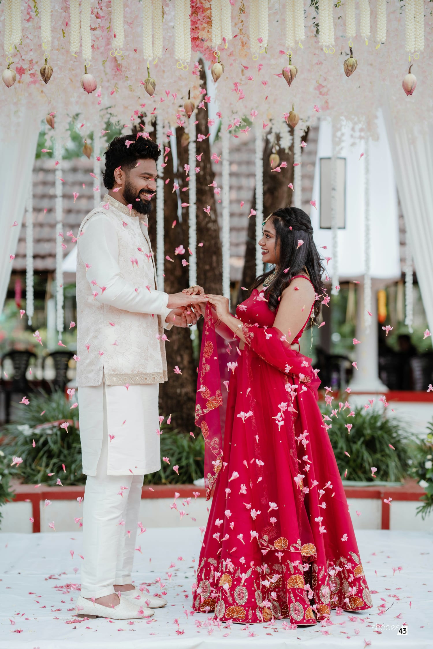Couple exchanging rings at a flower-filled Indian ceremony